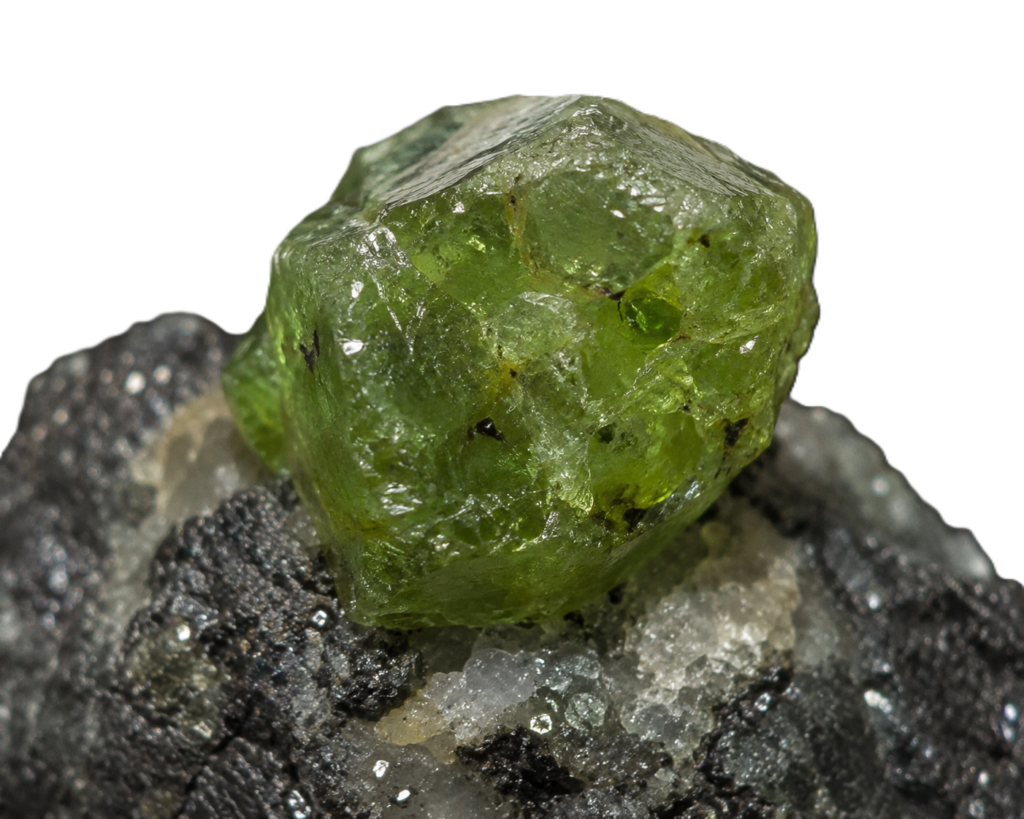 Raw Demantoid garnet crystal on its natural rock matrix showing transparent olive-green Andradite garnet.
