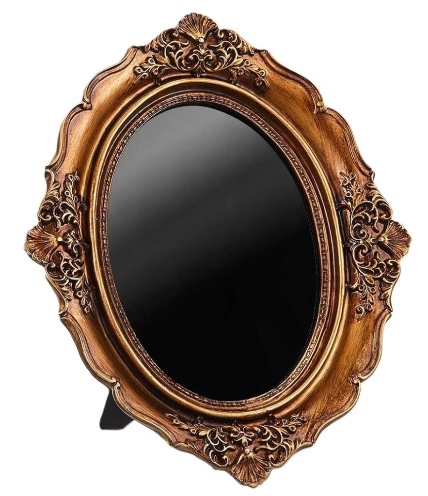 An ornate antique-style black scrying mirror with an oval obsidian-like reflective surface set within an intricately carved gold frame, used for divination, meditation and spiritual practice.