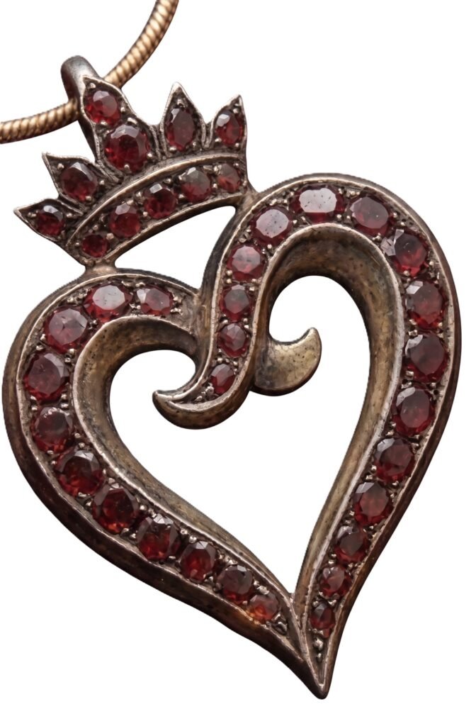 Crowned georgian witchs heart pendant with flatcut garnets sians emporium Antique georgian crowned witch's heart pendant featuring an asymmetrical curved tip set with flat-cut red garnets in oxidized silver-topped metal.