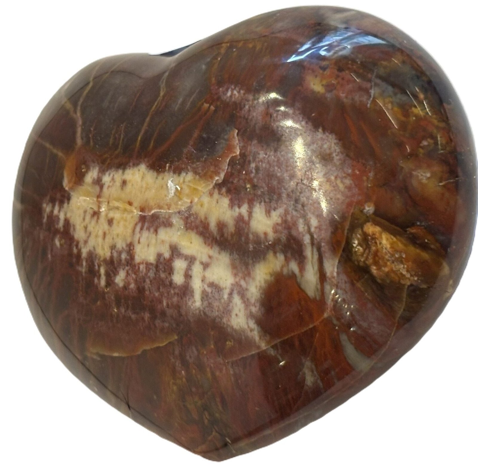 Carnelian heart 7 2 sians emporium Smooth polished carnelian carved heart palm stone with translucent amber red tones and natural circular orbicular inclusions isolated on a white background